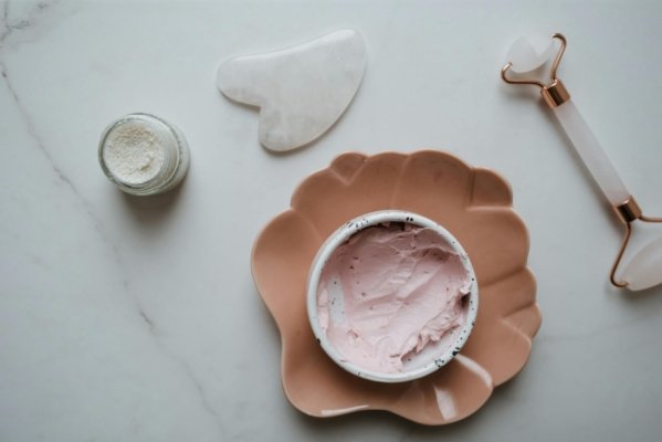 a set organic skinacare products used for skincare routine, rose quartz gua sha, face cream, and body cream