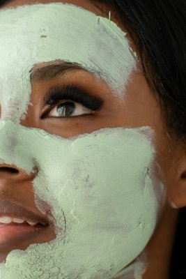 a woman's face using an organic green facemask