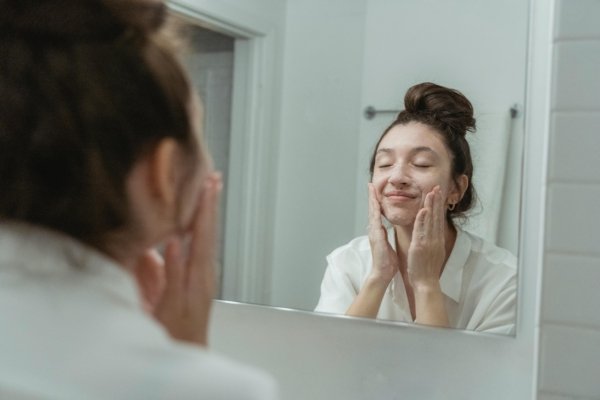 washing face in the mirror smiling